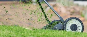 Picture of a lawn mower with wheels cutting grass